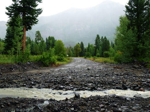 Road washed out by a rocky creek