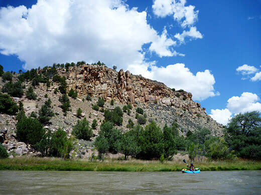 Paddling past desert brush and rocky slopes on the Rio Chama