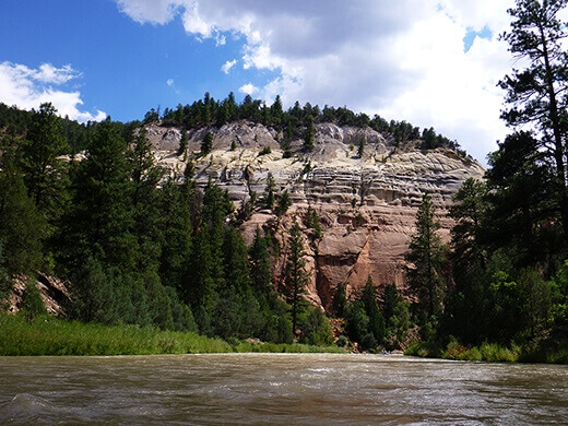 Canyon walls striped in vivid shades of vermillion, pink, yellow, and white