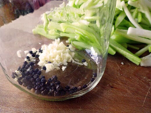 Pour a teaspoon of black peppercorns into each jar