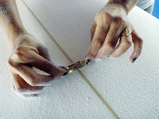 Using a spokeshave to whittle down excess wood on the stringer