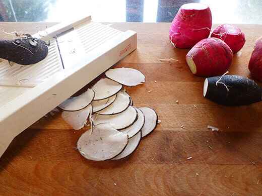 Thinly slice radishes using a mandoline