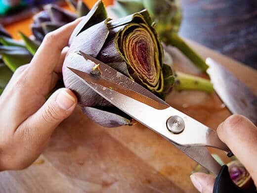 Snip the tips of artichoke leaves