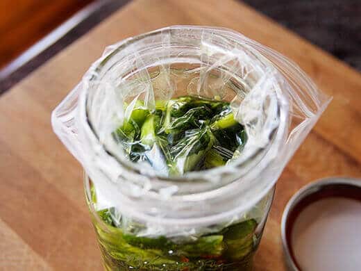 Line the jar with a weighted baggie to keep the veggies submerged