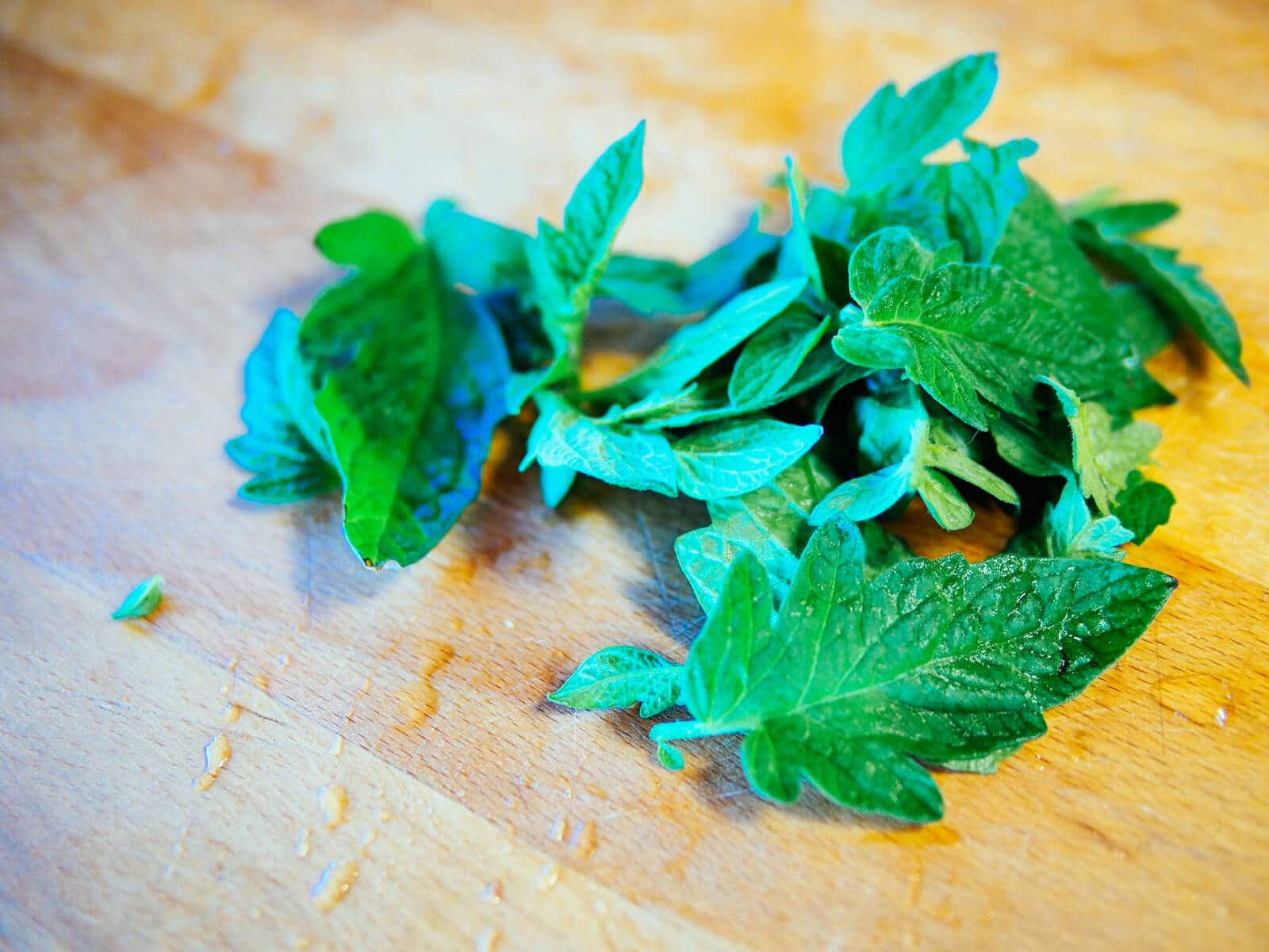 Tomato leaves, washed, on a cutting board