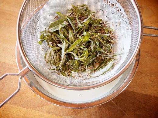 Strain lavender and lemon verbena over bowl of heavy cream
