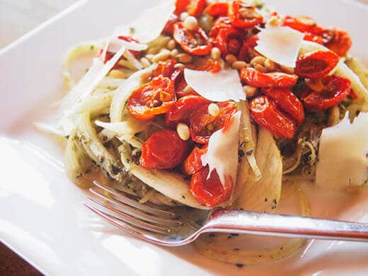 Zucchini noodles with roasted tomatoes, pesto, and pine nuts