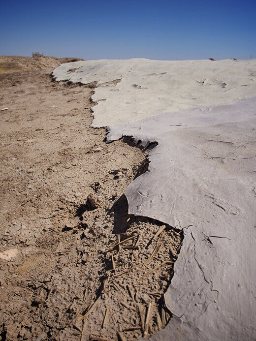Acrylic paint and adobe on cracked earth