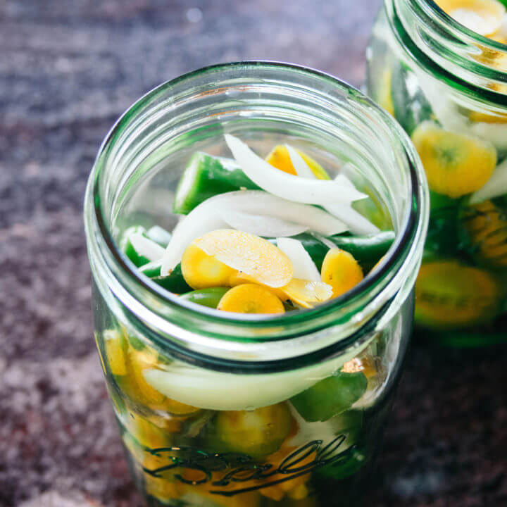 Layer the peppers, carrots, and onions in a jar