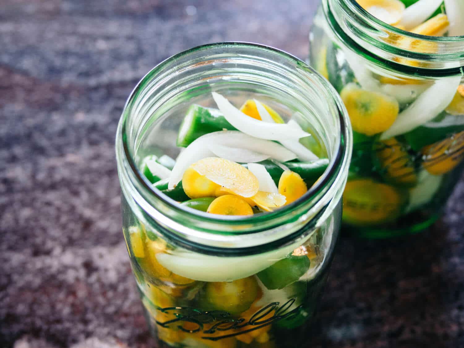 Layer the peppers, carrots, and onions in a jar
