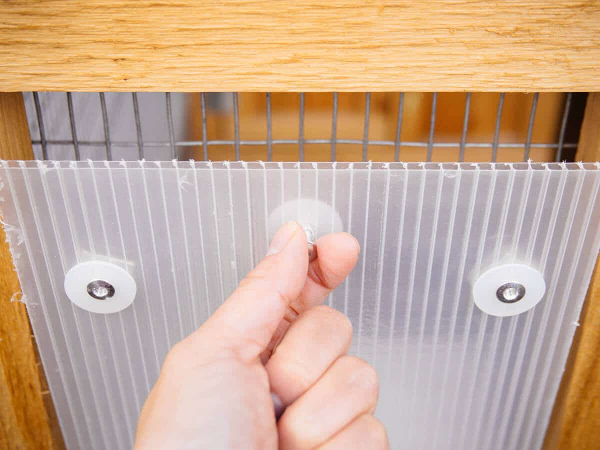 Corrugated plastic storm panels attach to the coop with magnets