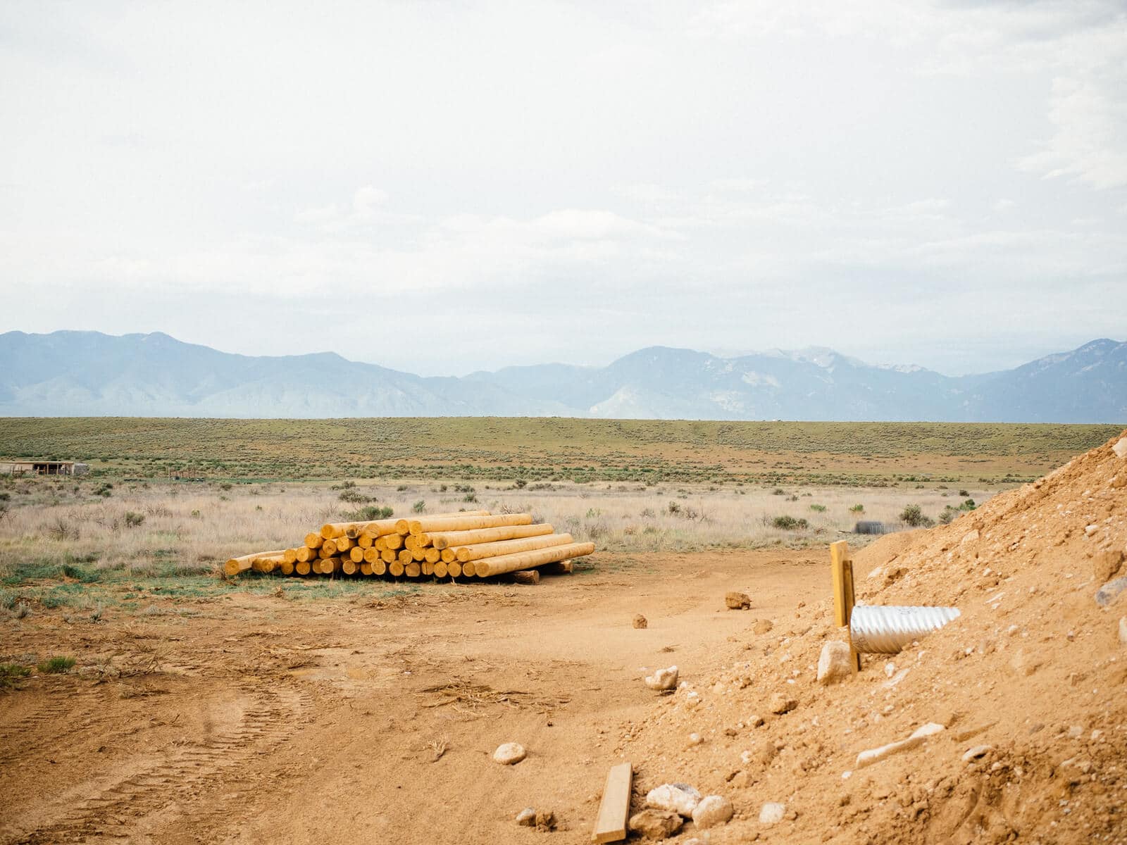 Logs piled up at an Earthship construction site