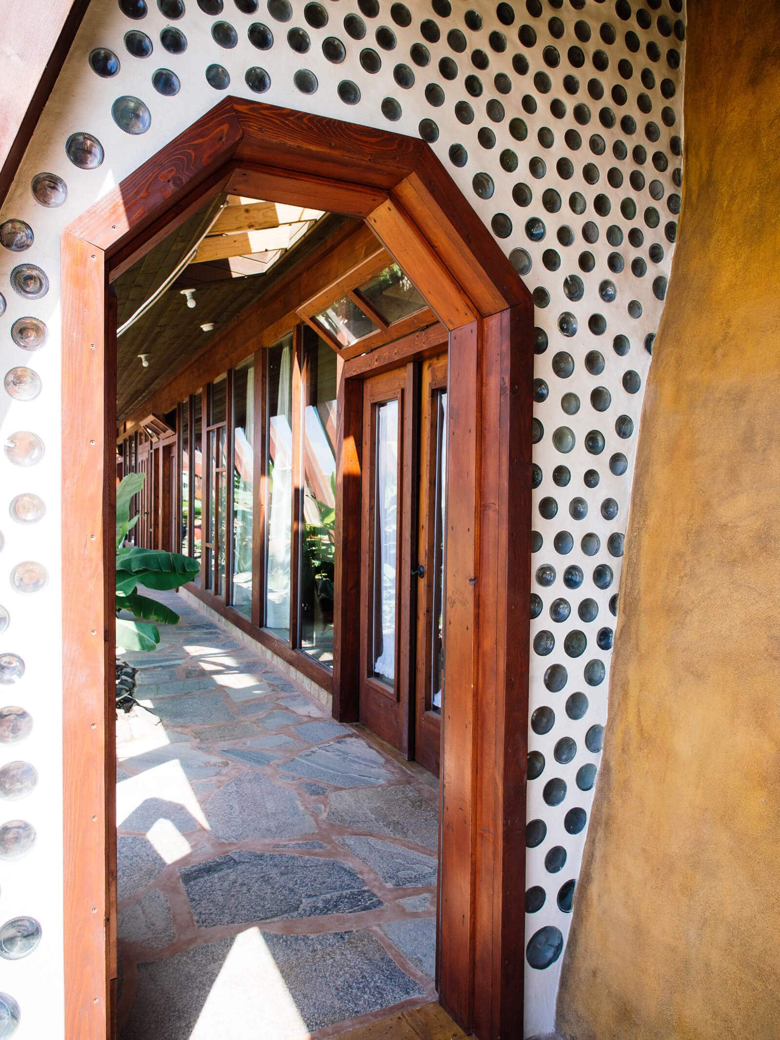 Whimsical doorway in an Earthship made from reclaimed wood and glass bottles