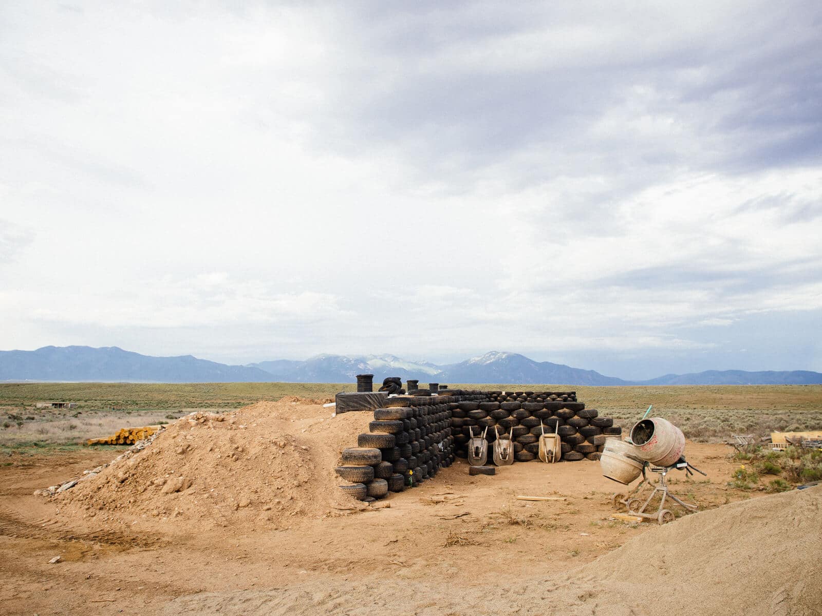 Constructing the rammed-earth tire walls of an Earthship to create thermal mass