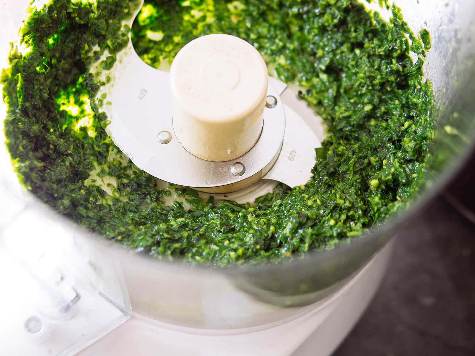 Basil mixture in the bowl of a food processor
