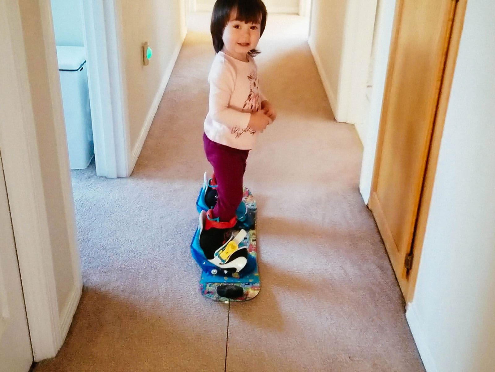 Toddler "snowboarding" on carpet inside the house for practice