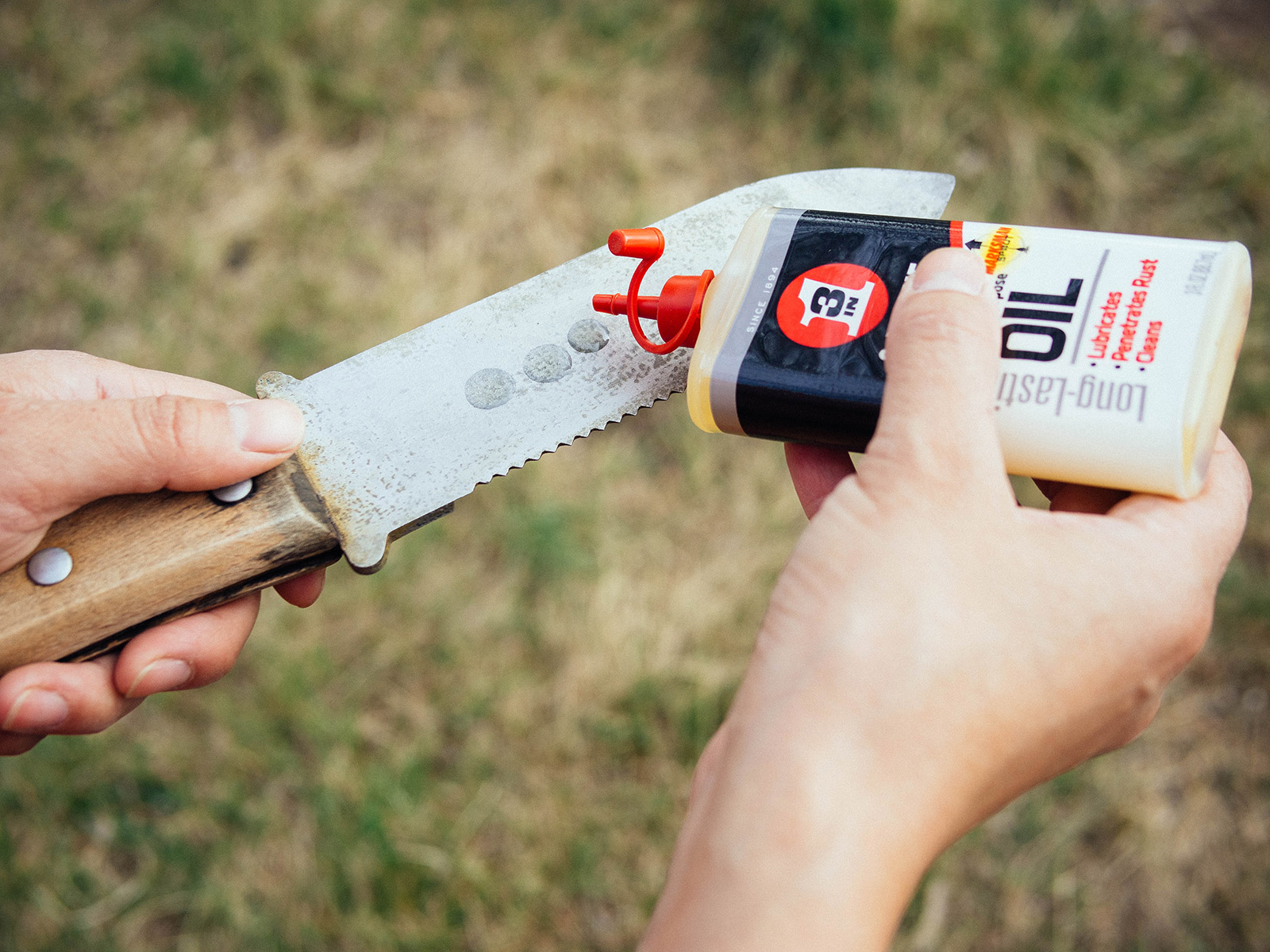 Woman adding a few drops of 3-IN-ONE Multi-Purpose Oil to a hori hori knife blade