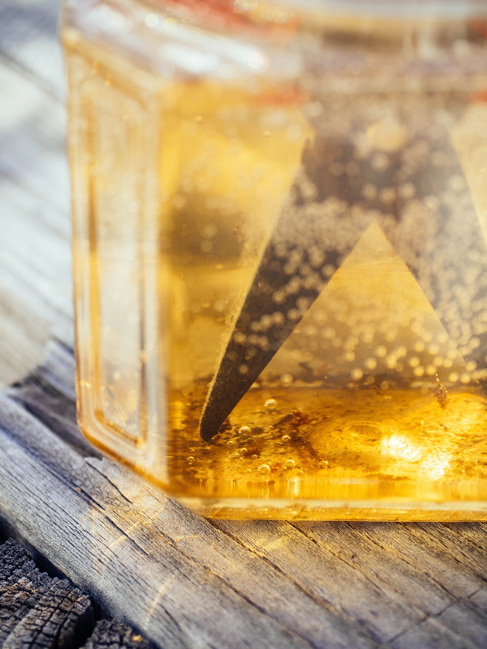 Close-up of loosened and dissolved rust flakes sitting in a jar of vinegar