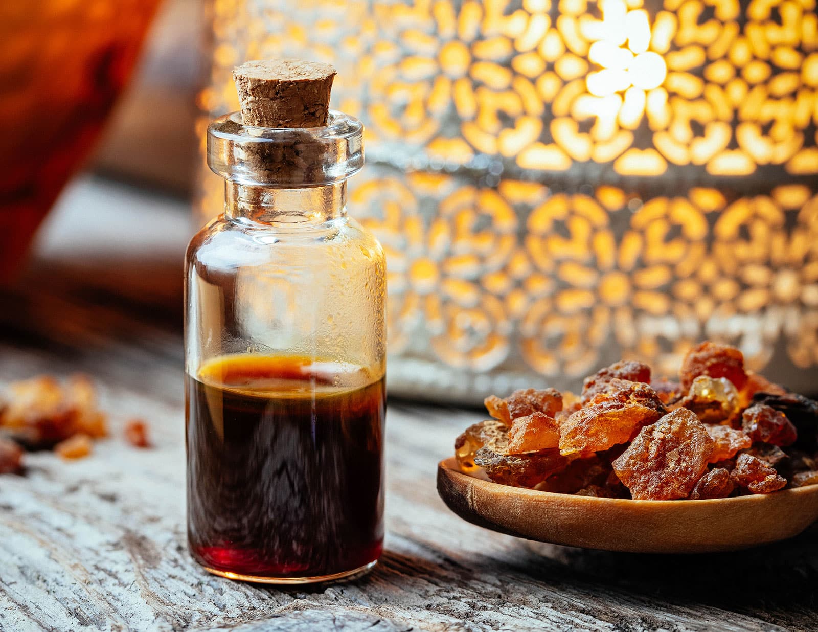 Jar of myrrh essential oil next to a dish of myrrh resin