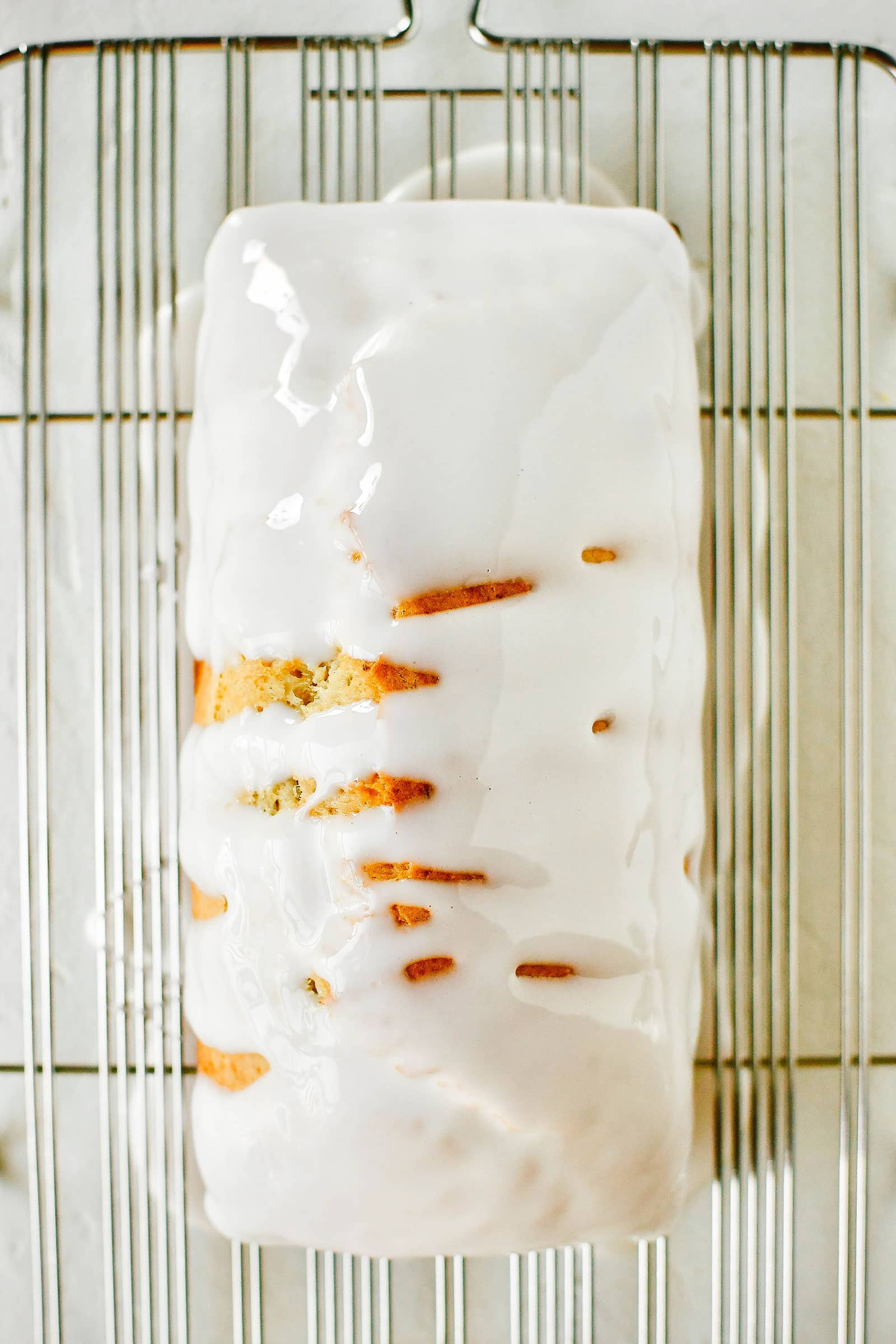 Grapefruit-rosemary bread loaf on a cooling rack with grapefruit glaze poured on top