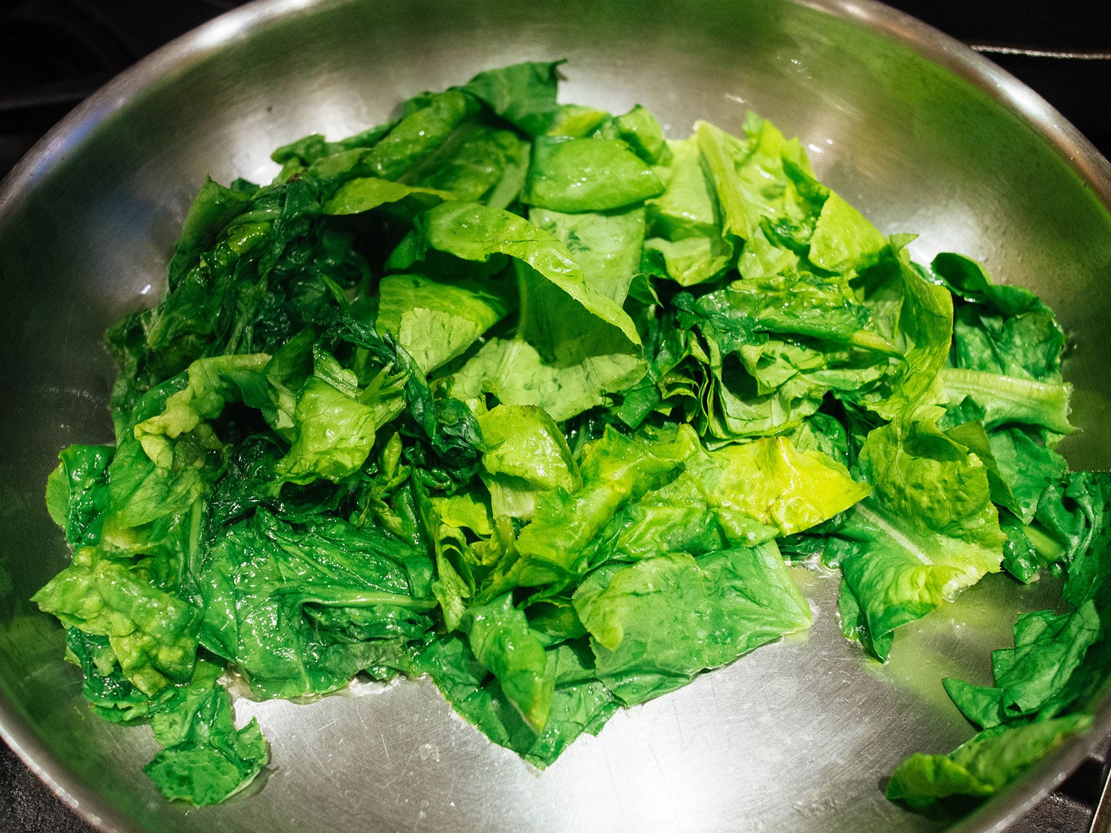 Lettuce sauteed in a stainless steel pan